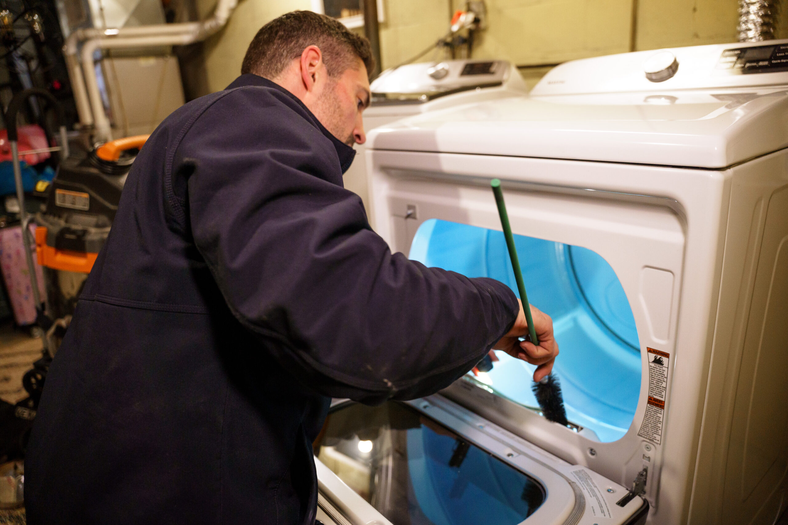 A dryer vent technician cleans the lint screen